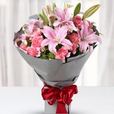 Bunch of Pink Carnation 9 stems & 2 stems of pink lilies in round style paper wrapped, red gift ribbon tied mixed bouquet. Mixed bouquet