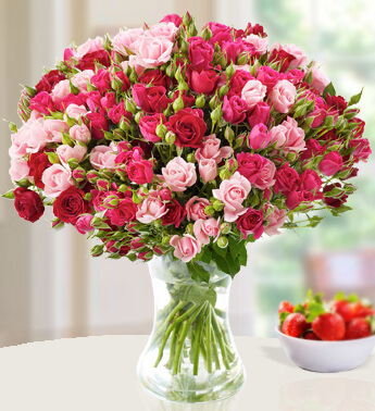 Arrangement of 75 Roses Big Head and 15 stems of spray Red and Pink Roses with fillers in a glass vase. Pretty Petals