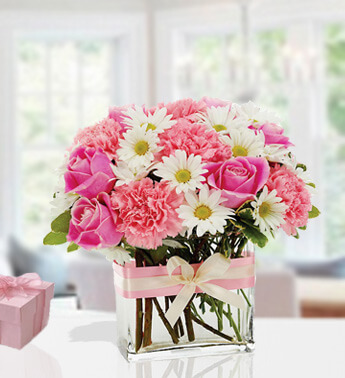 Arrangement of 4 stems of White Chrysanthemums, 6 stems of Pink Carnation and 5 stems of Pink Rose in a cube glass vase. Pink Sophistication