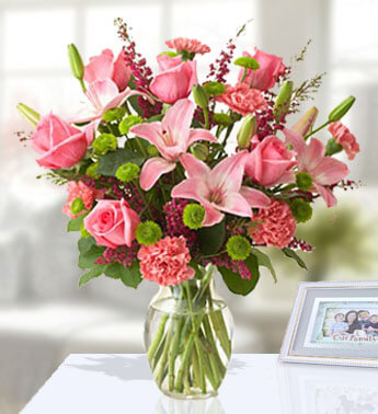 12 stems of Pink Carnation, 4 stems of Green Chrysanthemum, 4 stems of Pink Lily, 10 stems of Pink Rose in a glass vase. (one sided arrangement) Thinking About You!