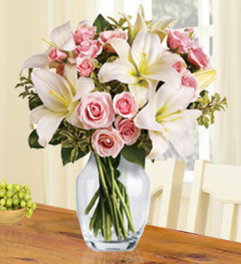 2 stems of White Lily and 15 Peach Roses in a glass vase. (one sided round arrangement) French Country Collection