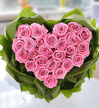 Heart shape arrangement of 24 Pink Roses with green leaves. Elegant Sweetheart